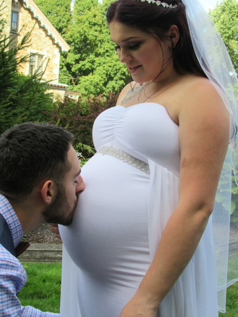 A man kissing his pregnant wife’s stomach