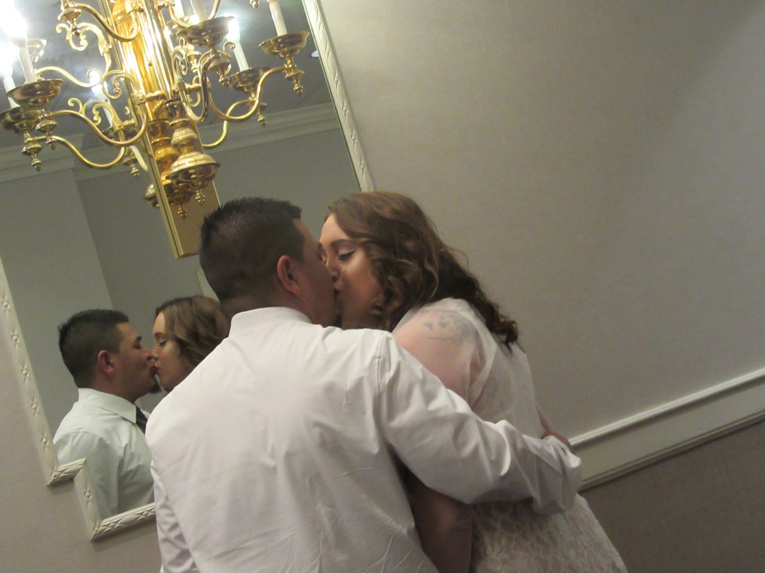 A couple kissing in front of a mirror