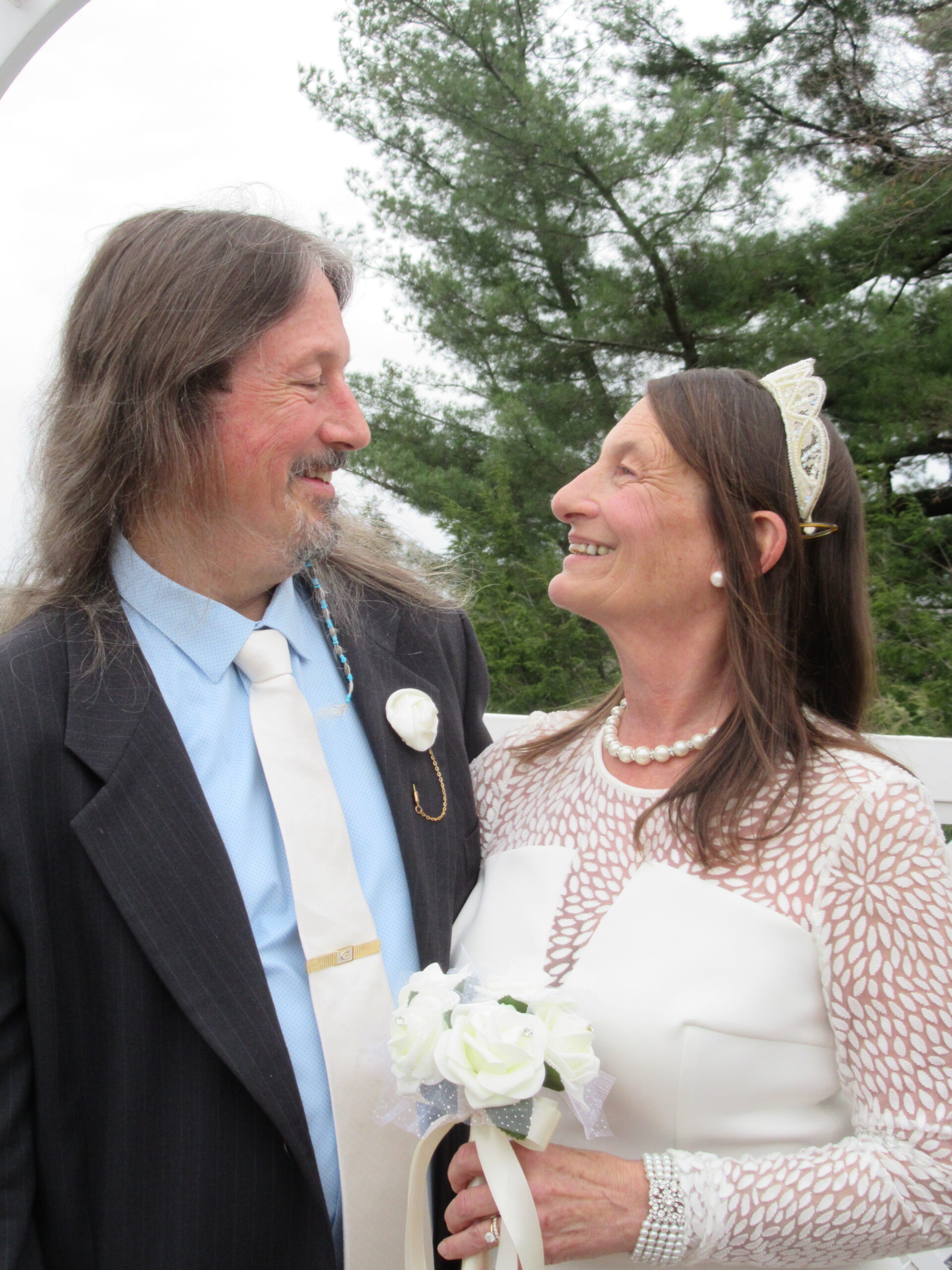 An older couple wearing wedding outfits