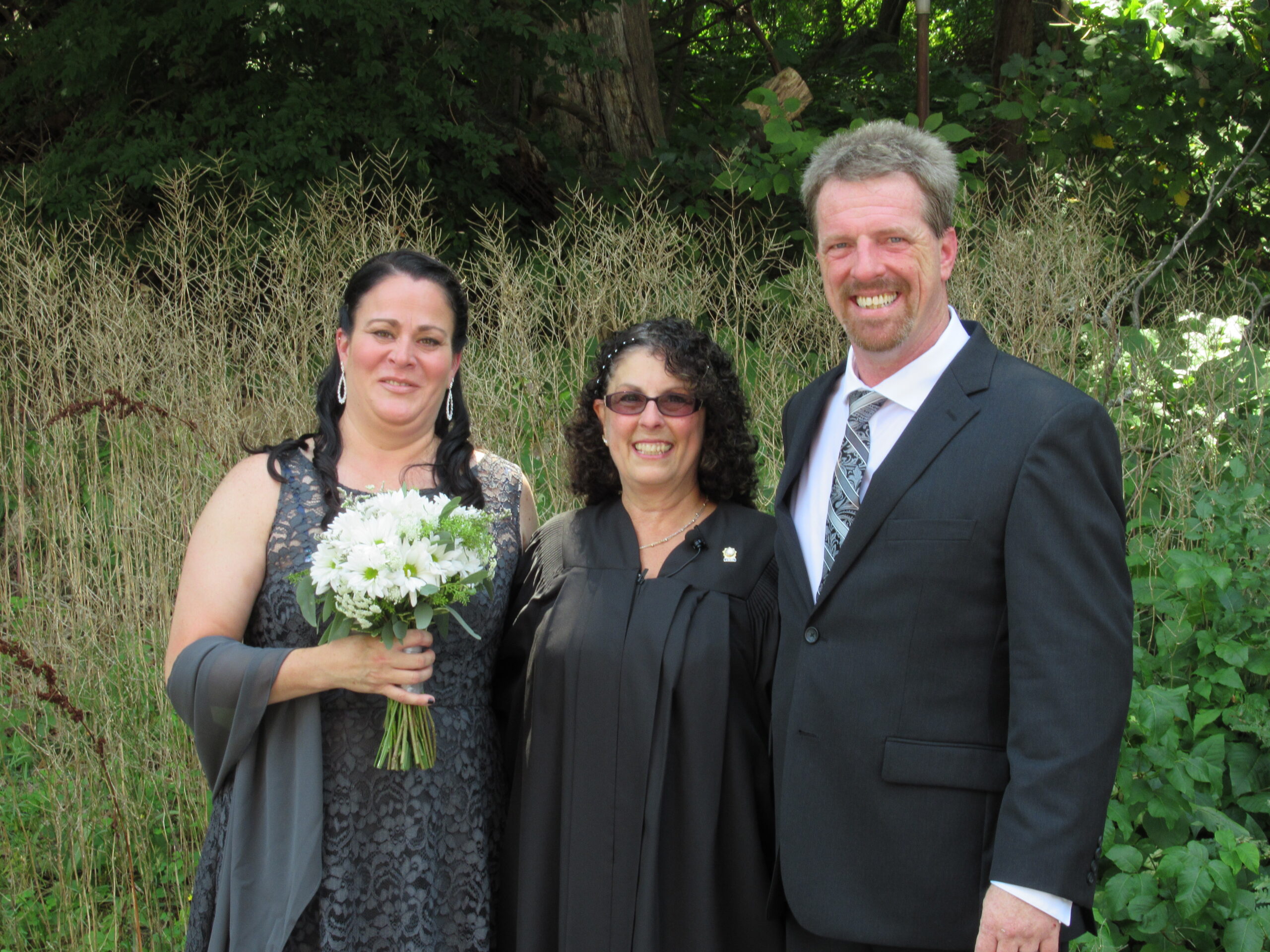 A newly wed couple taking a picture with Carol Roberts