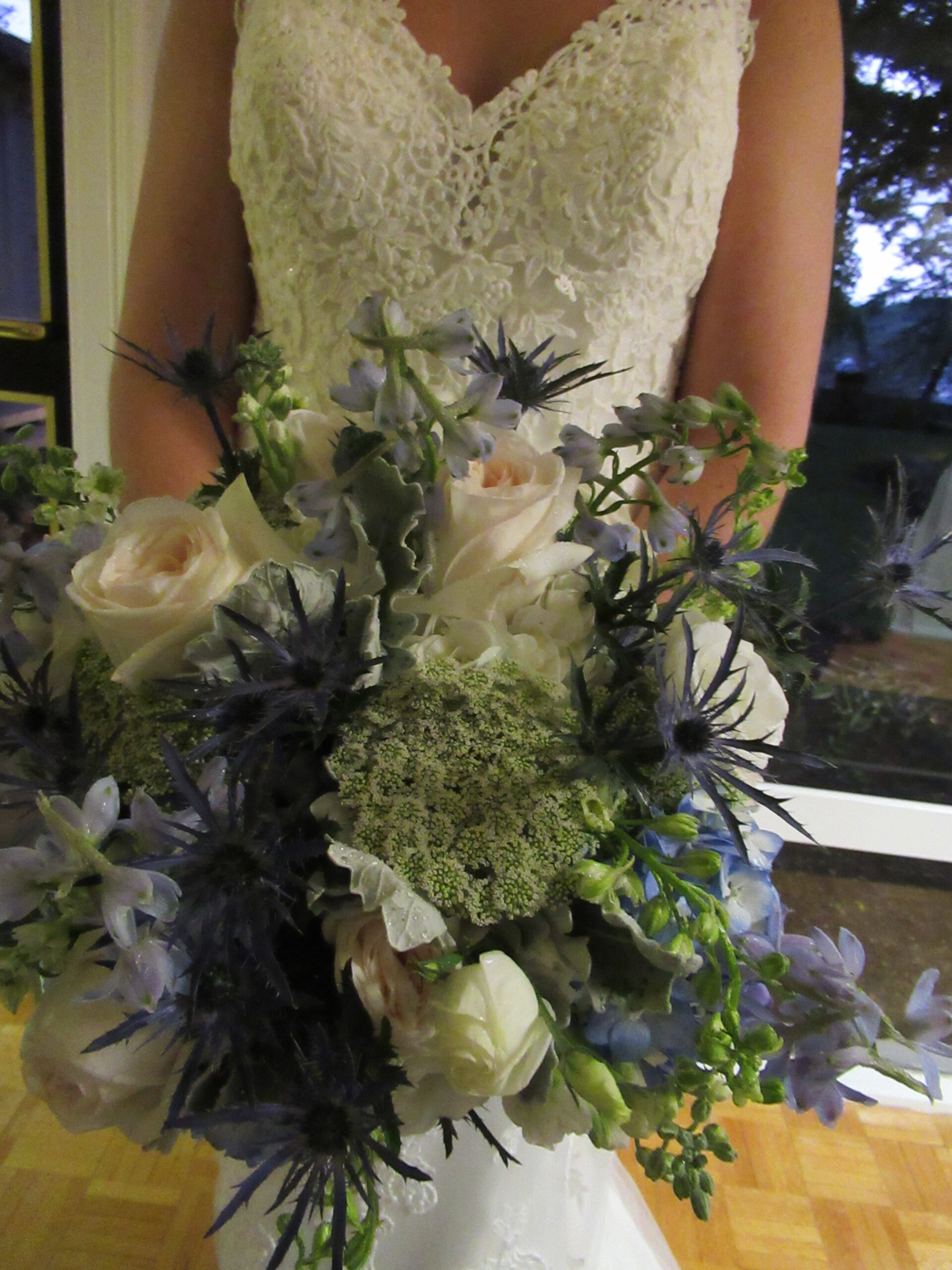 A bride holding a beautiful bouquet of blue and white flowers