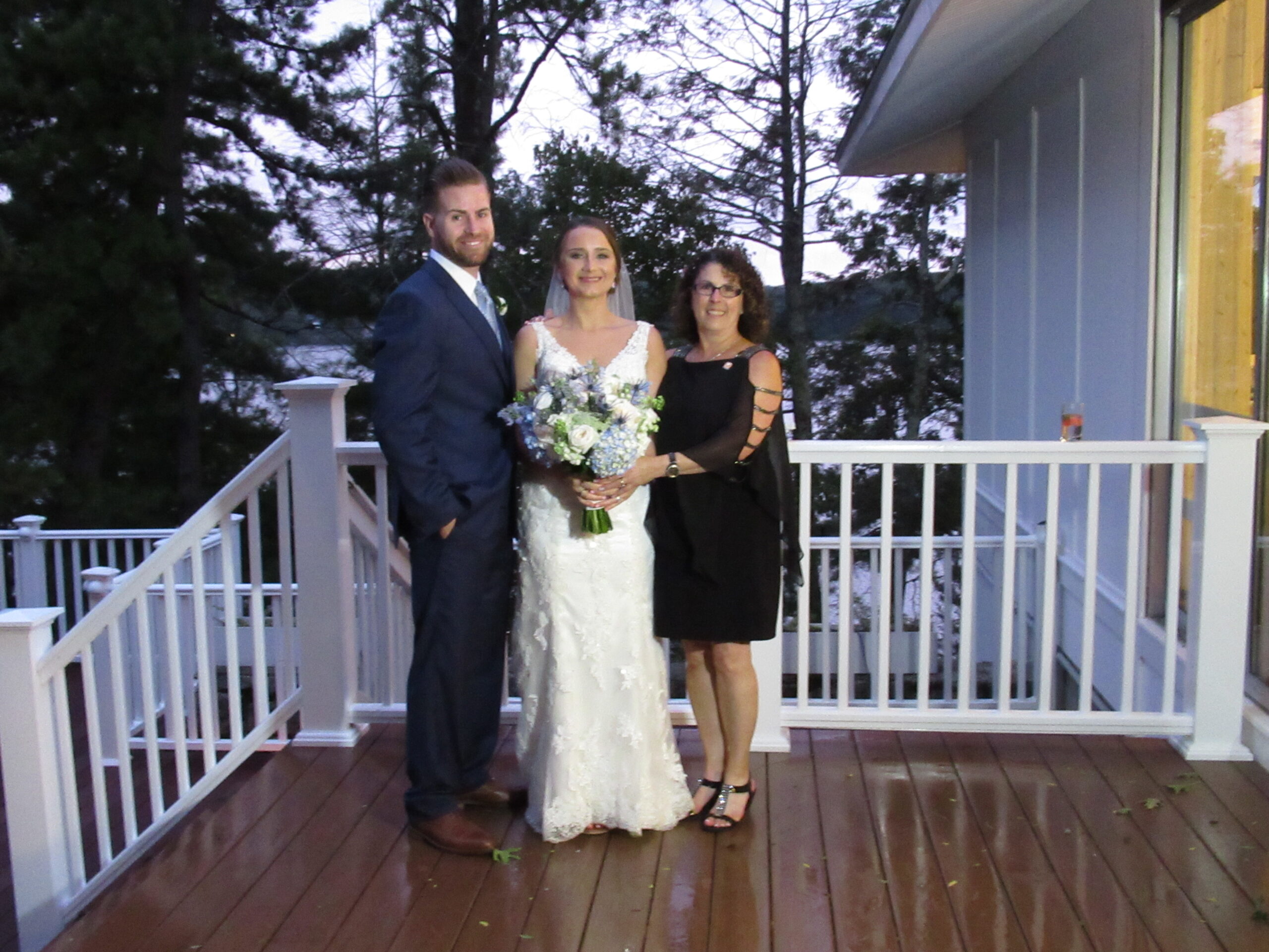 A newly wedded couple taking a picture with an older woman